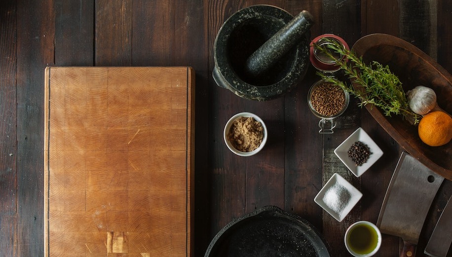 Table with cooking spice, mortar and pestle, knives, and leather book